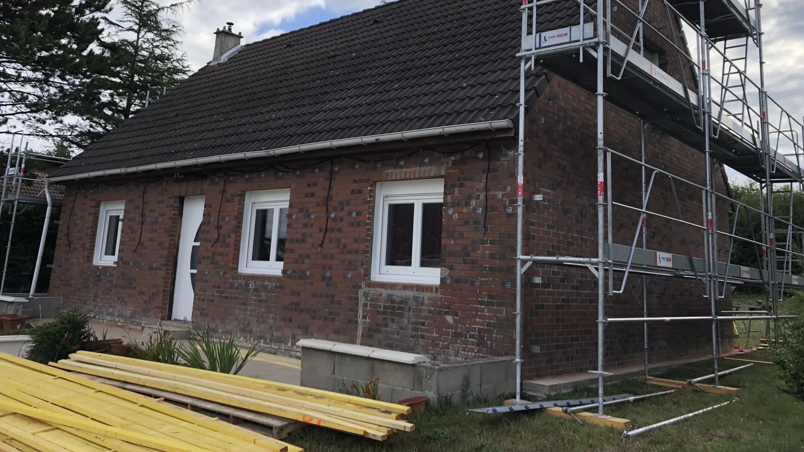 Maison de brique sous échafaudage avant la pose de l'isolation extérieure