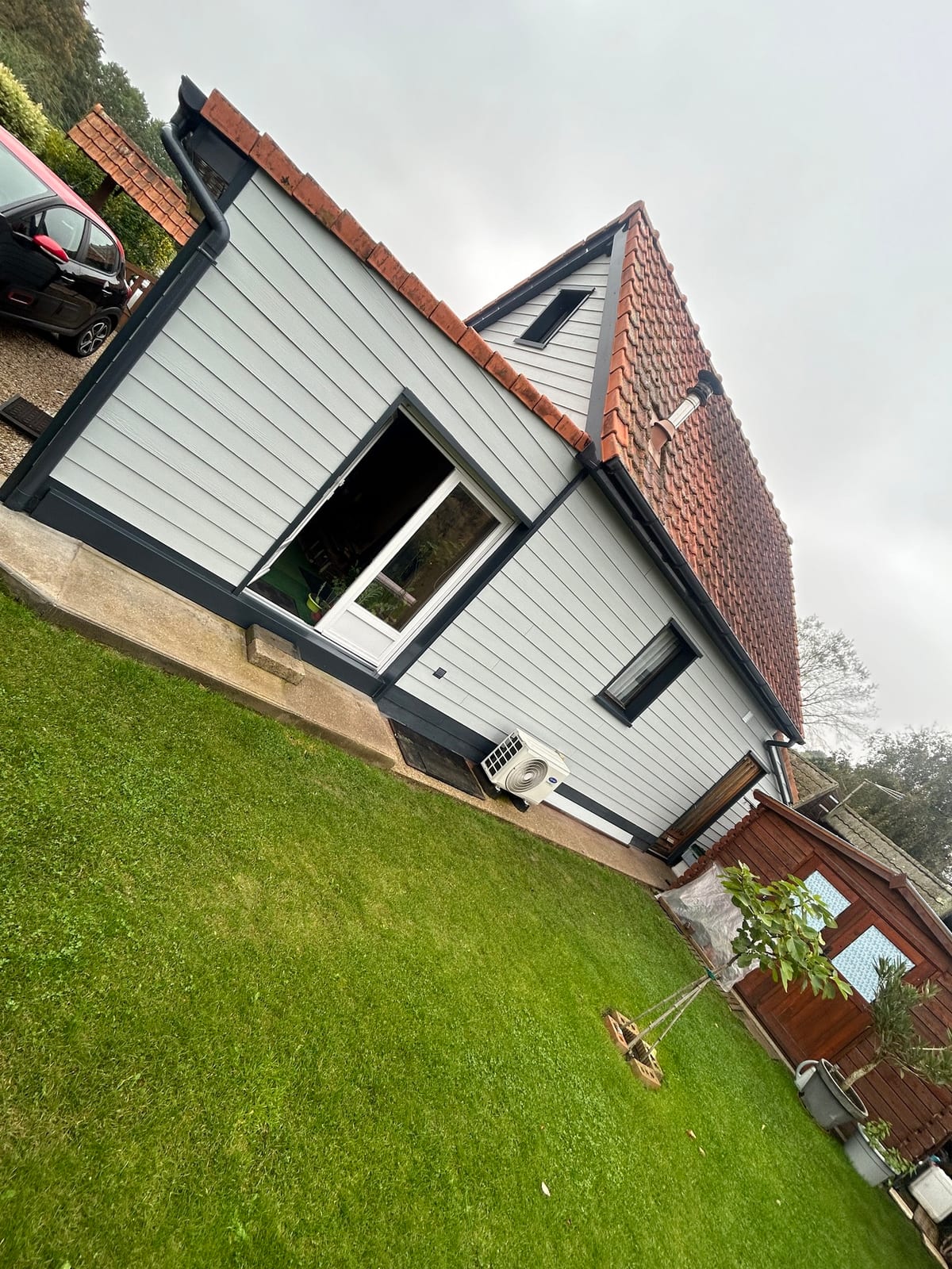 Extension de maison avec bardage gris à claire-voie réalisée par Hapînov dans le Pas-de-Calais