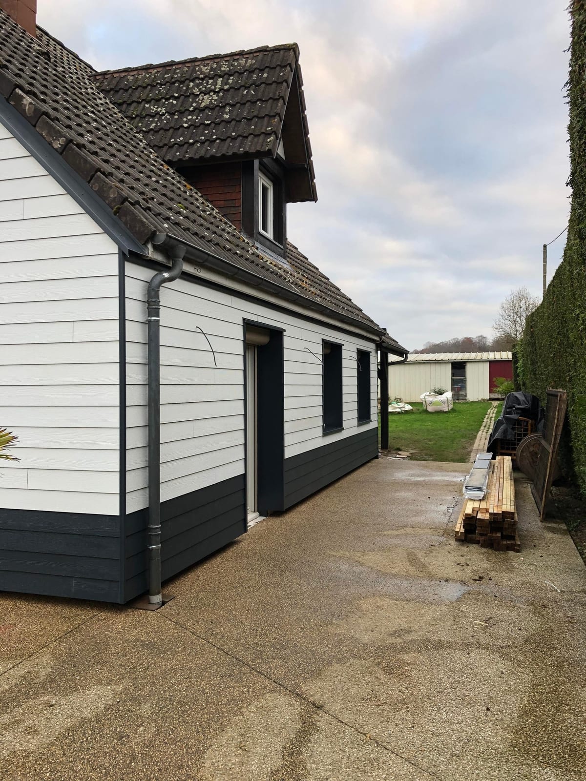 Façade rénovée avec bardage blanc et soubassement anthracite par Hapînov dans le Pas-de-Calais
