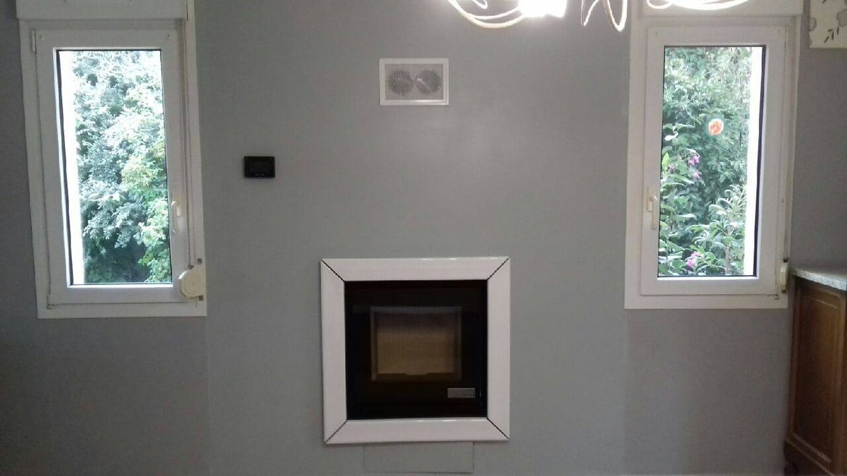 Insert poêle à bois blanc encastré dans un mur par Hapînov