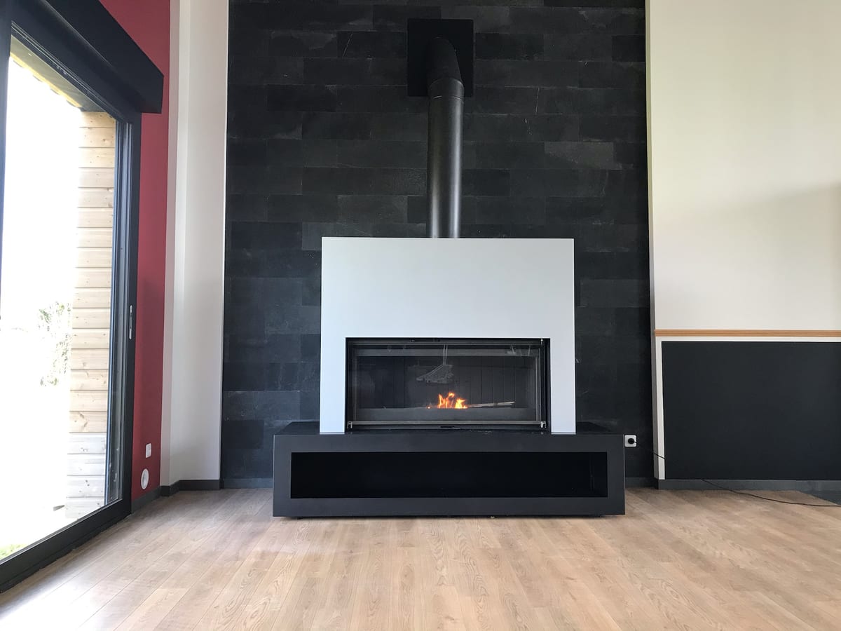 Poêle à bois moderne avec habillage en parement ardoise dans un salon contemporain installé par Hapînov