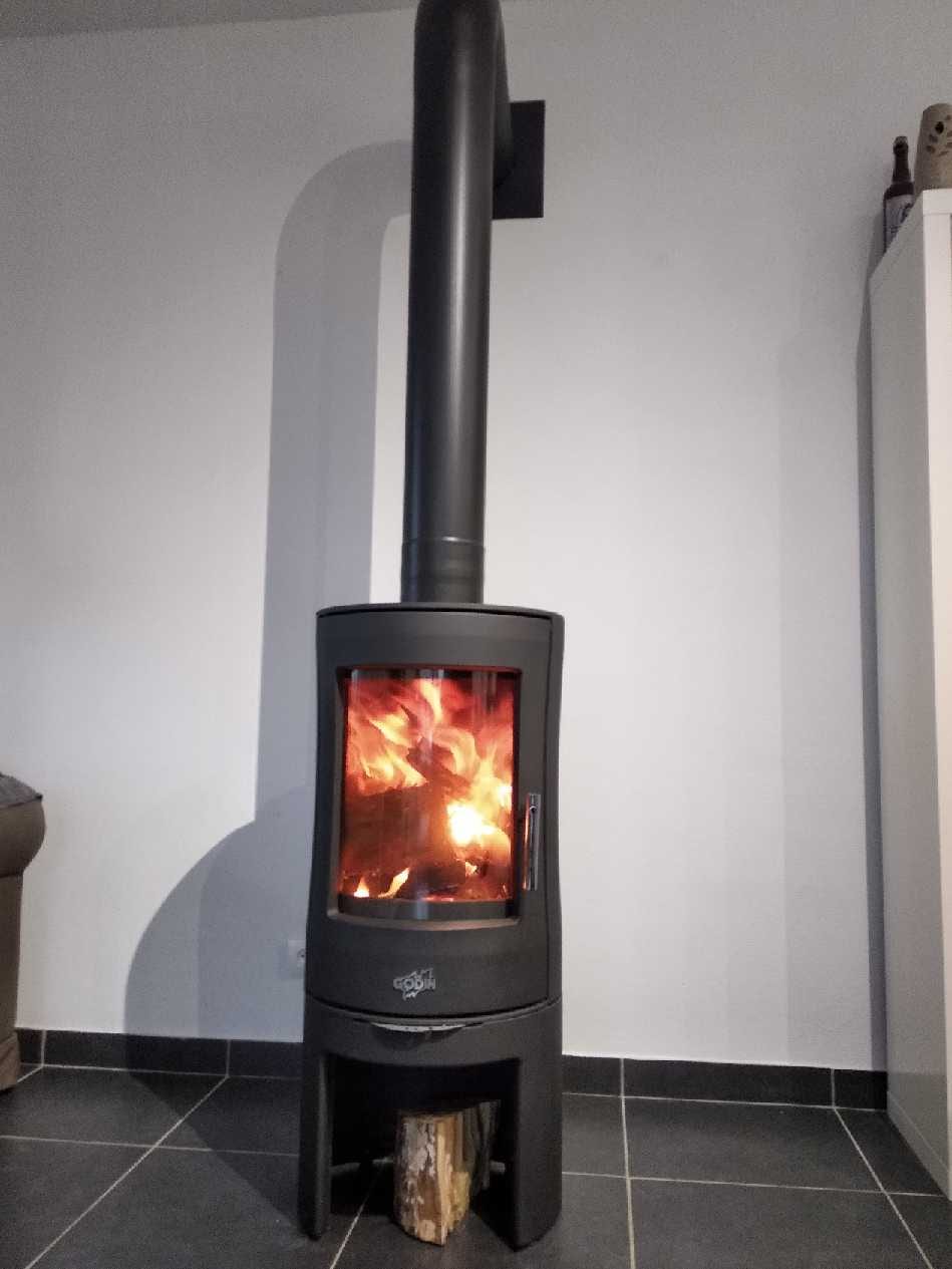 Poêle à bois Godin cylindrique installé en angle de salon par Hapînov